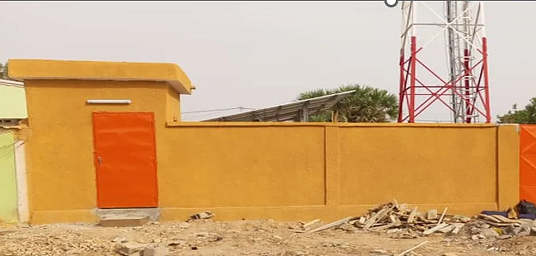 Mur de clôture, guérite à porte orange et portail d'un site télécom sécurisé par TENERGY